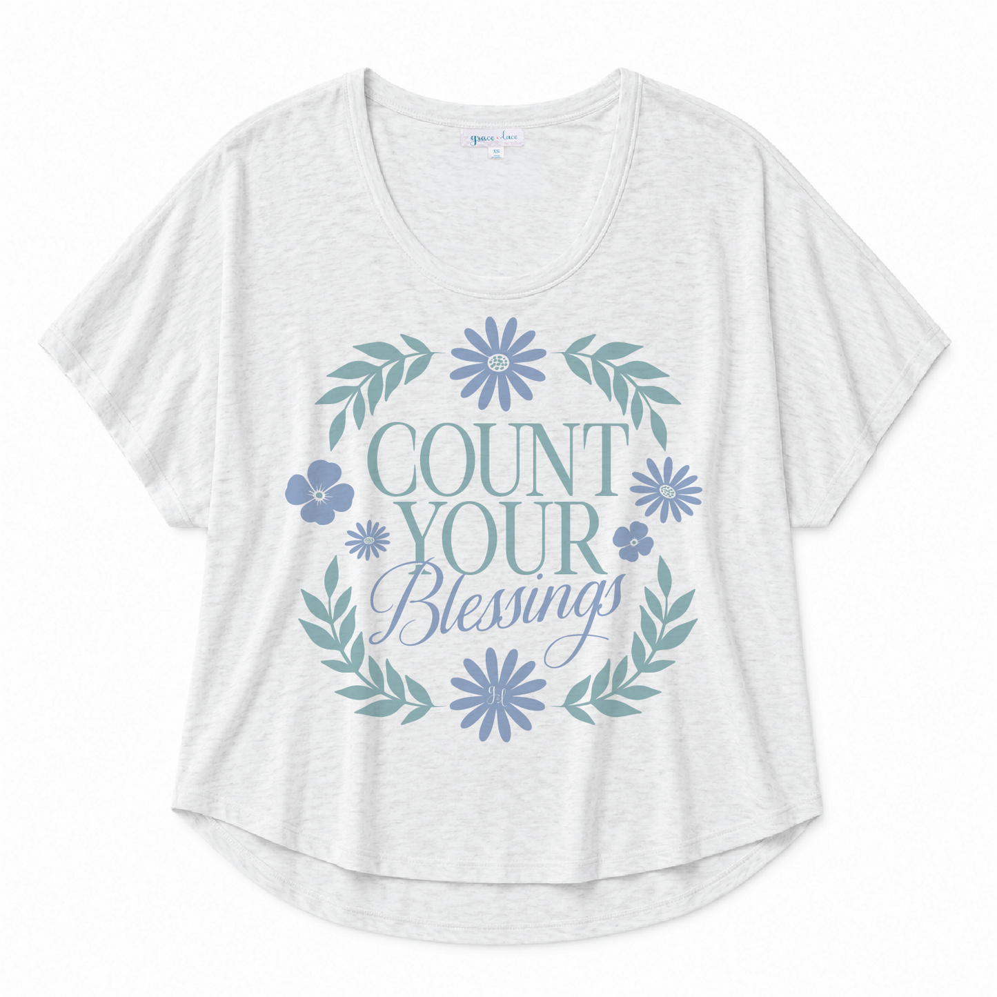 White scoop neck tee featuring a "Count Your Blessings" floral graphic in blue and green tones on a white background