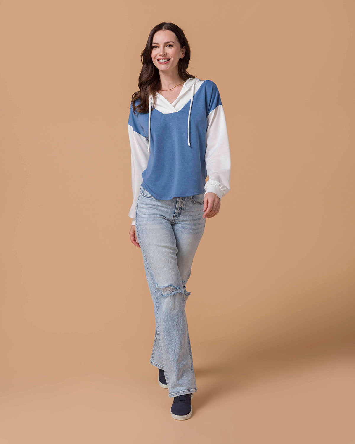 Brunette Model wearing Pullover V-Neck Color Block Hoodie in Blue & White and denim jeans walking