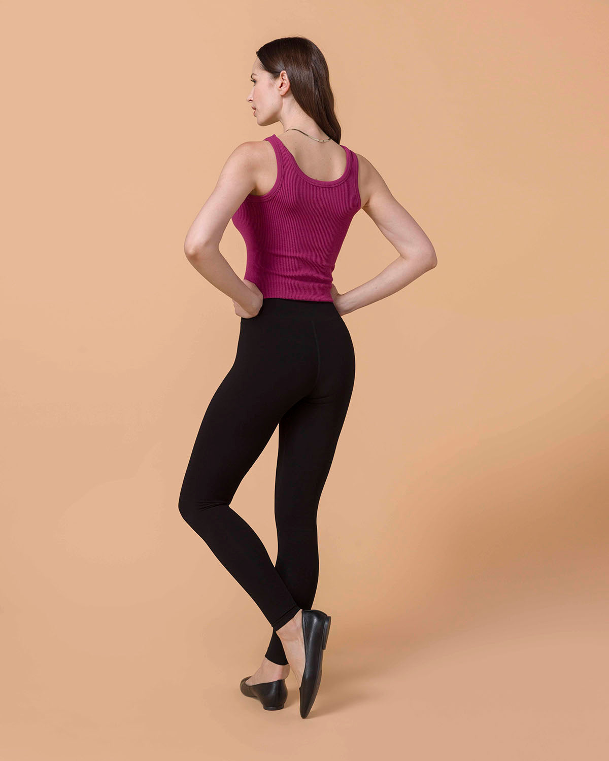 Brunette Model wearing Signature High-Rise Black Leggings and berry brami back view