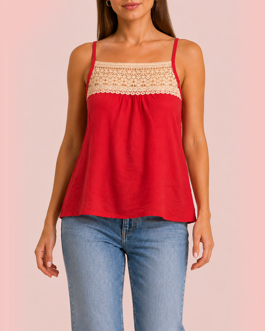 Effortless Lace Trim Tank in Coral Front view of a woman wearing a coral camisole top with a crochet lace yoke and blue jeans on a beige background
