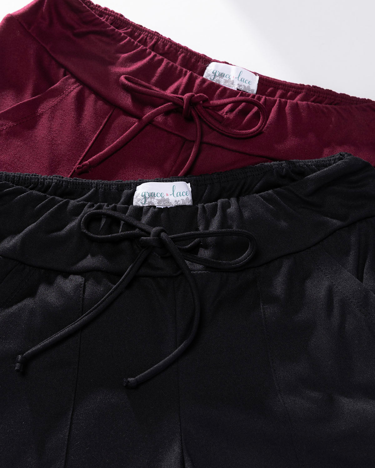 Close-up of black and maroon pants, with Grace & Lace labels on a white background.