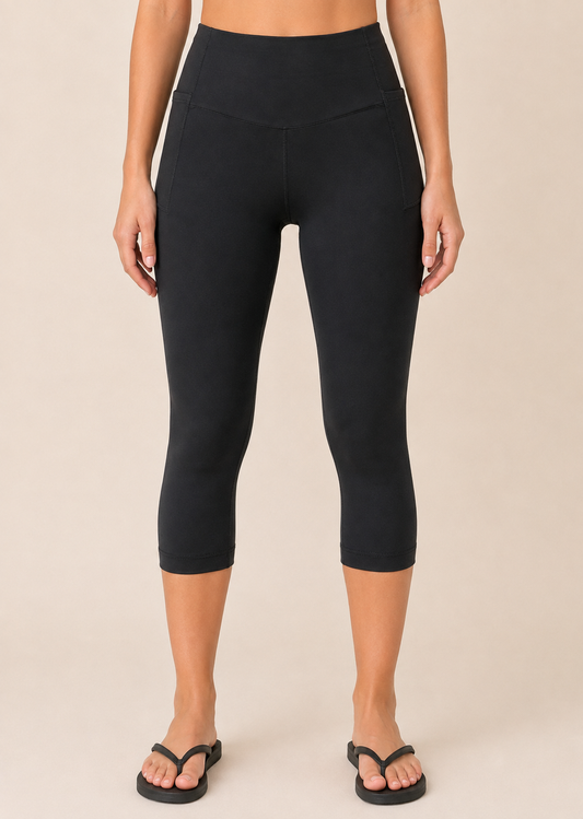 Daily Capri Leggings with Pocket in Black Full-body view of a woman wearing black capri leggings with a white top, pink cardigan, headband, and black sandals on a beige background