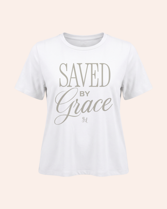 Saved by Grace Vintage Tee in White Person wearing a white t-shirt with 'Saved by Grace' text on a beige background