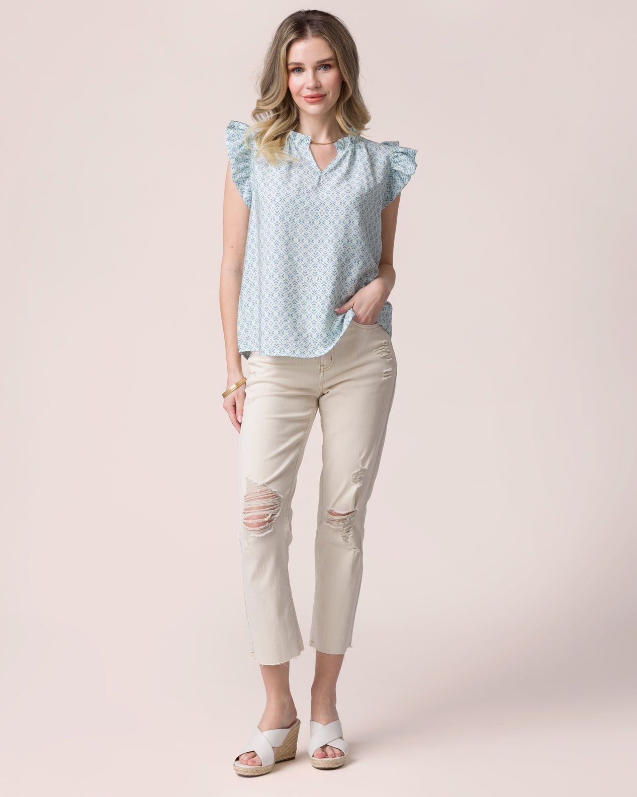 Brunette woman wearing a white tee sitting on stool