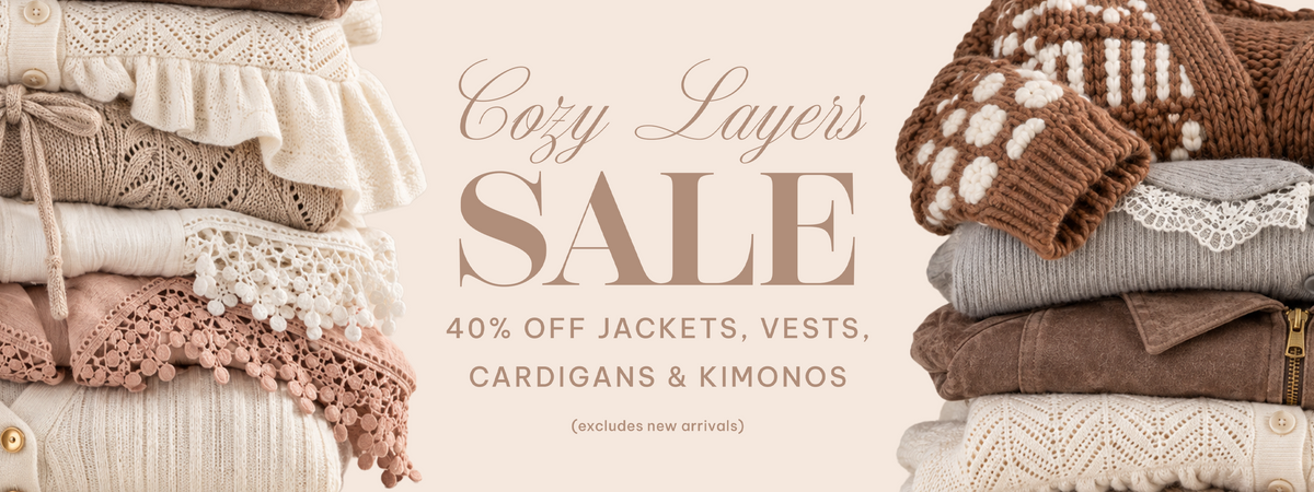 A promotional banner for Cozy Layer's Sale featuring stacks of cozy knit garments in cream, beige, brown, and gray tones on both sides, with large text in the center reading 'Cozy Layer's SALE' and smaller text offering 40% off jackets, vests, cardigans, and kimonos.