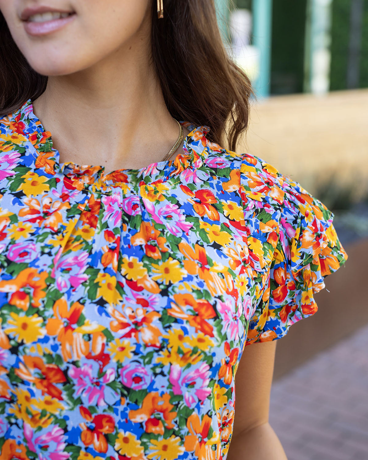 close up view of neck line and sleeve detail on freesia floral women's blouse