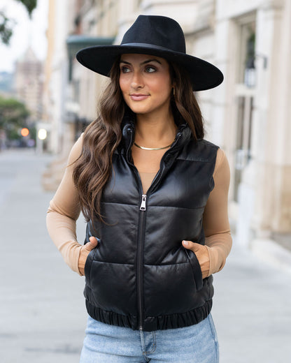 zipped view of black faux leather puffer vest