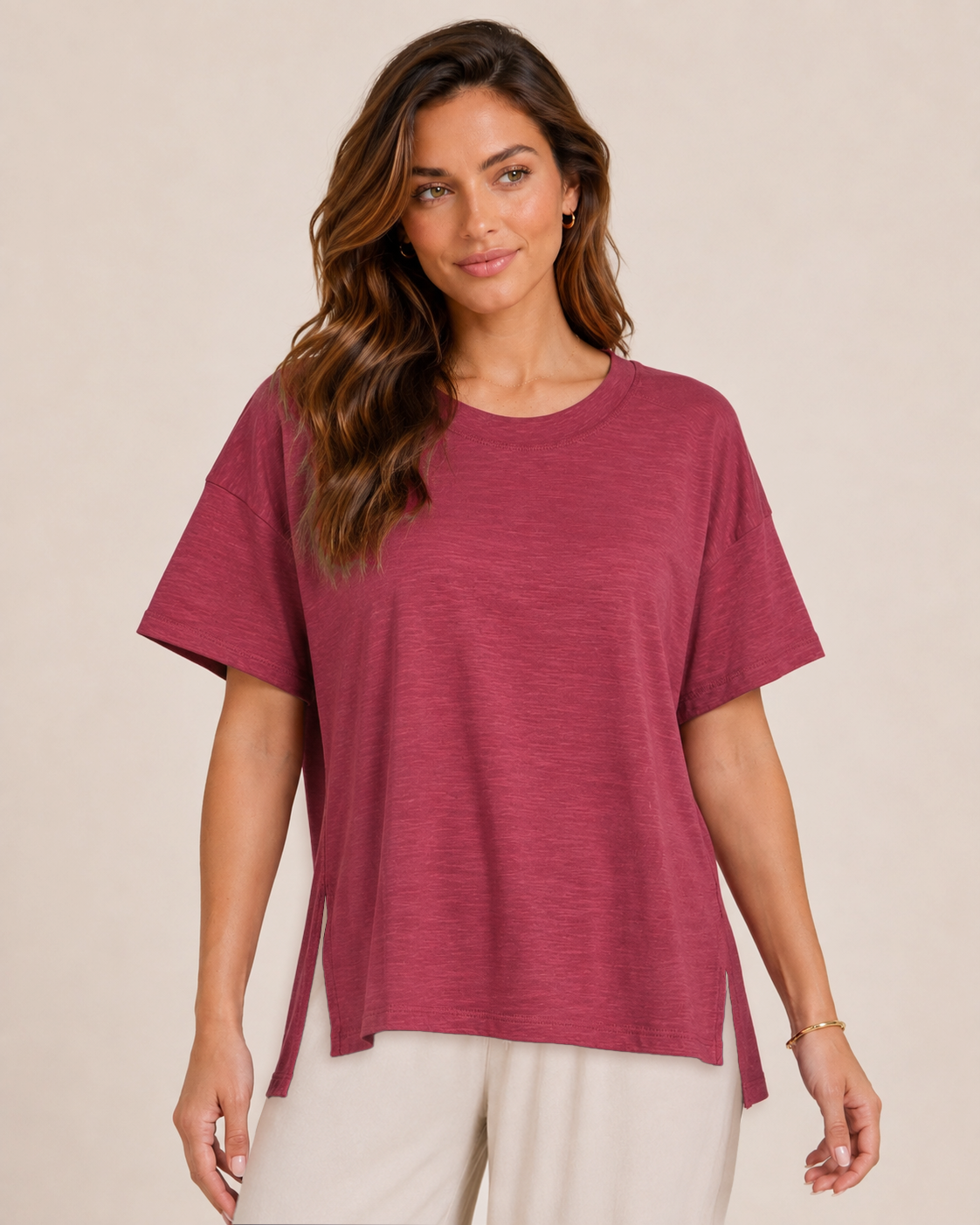 Close-up view of a woman wearing a Berry Ice cotton slub tee with white wide-leg pants  on a beige background