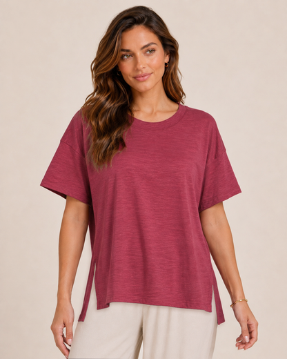 Close-up view of a woman wearing a Berry Ice cotton slub tee with white wide-leg pants  on a beige background