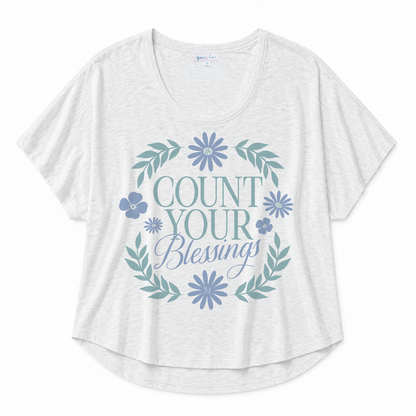 White scoop neck tee featuring a "Count Your Blessings" floral graphic in blue and green tones on a white background