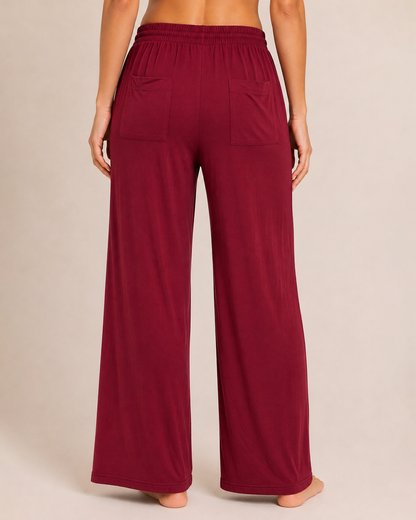Back view of a woman wearing cabernet wide-leg pajama pants on a beige background