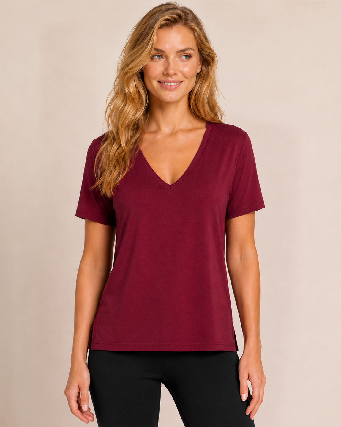 Close up front view of a woman wearing a cabernet V-neck pajama top with matching wide-leg pants on a beige background
