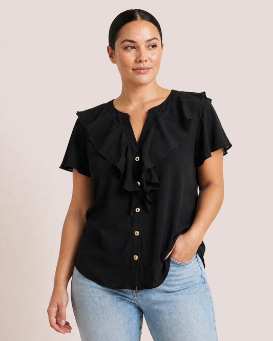 Elegant Easy Button Blouse in Black untucked on model with jeans