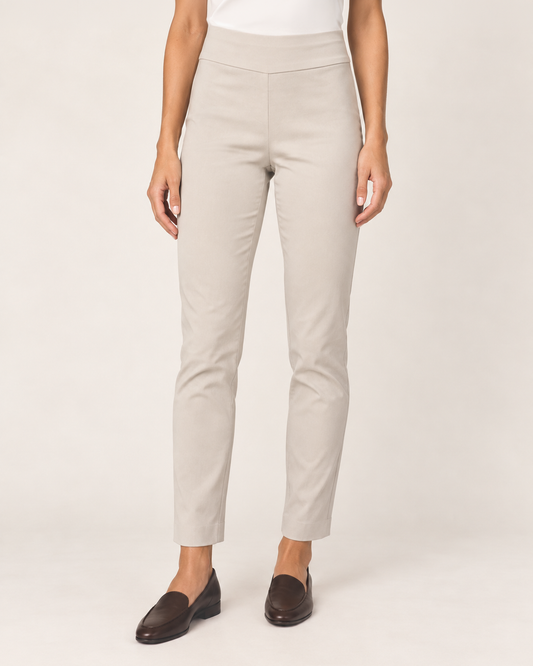 Full-body front view of a woman wearing tan ponte pants with a white blouse, burgundy cardigan, and black loafers on a beige background