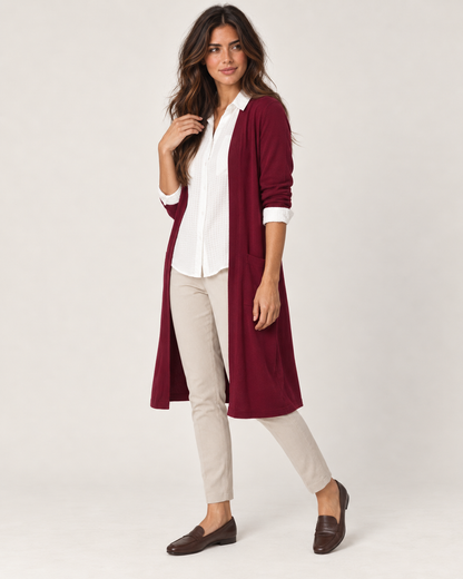 Full-body front view of a woman wearing tan ponte pants with a white blouse, burgundy cardigan, and black loafers on a beige background