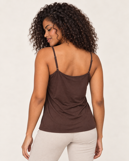 Back view of a woman wearing a brown spaghetti-strap tank top with white wide-leg pants on a beige background