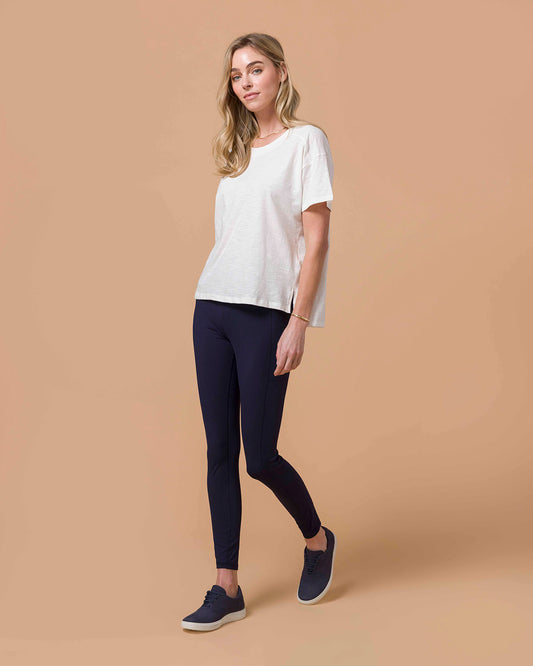 Blond woman wearing Navy Squat Proof Leggings with White top.