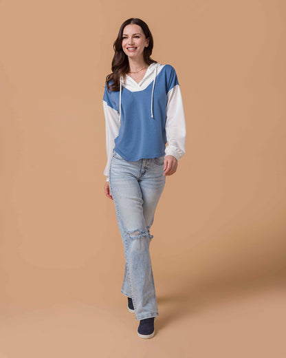 Brunette Model wearing Pullover V-Neck Color Block Hoodie in Blue & White and denim jeans walking