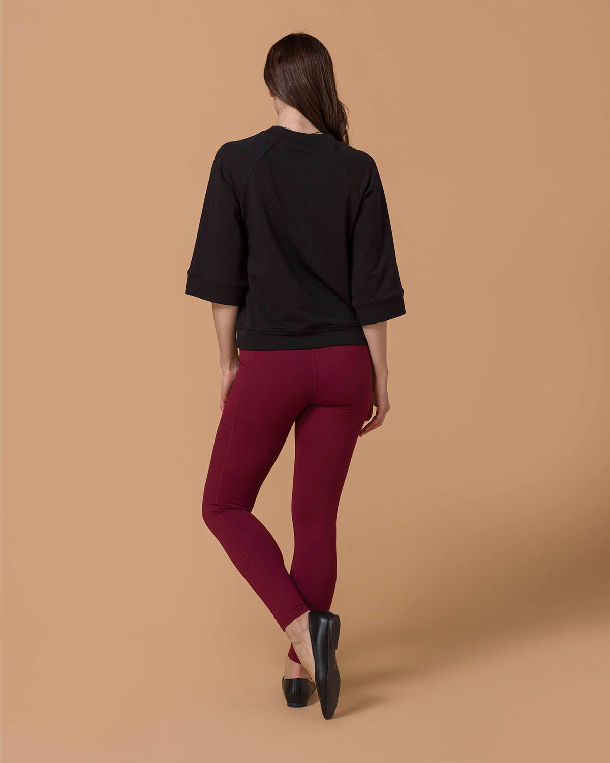 Woman wearing Best Squat Proof Leggings with Pocket in Cranberry and Black top showing back view