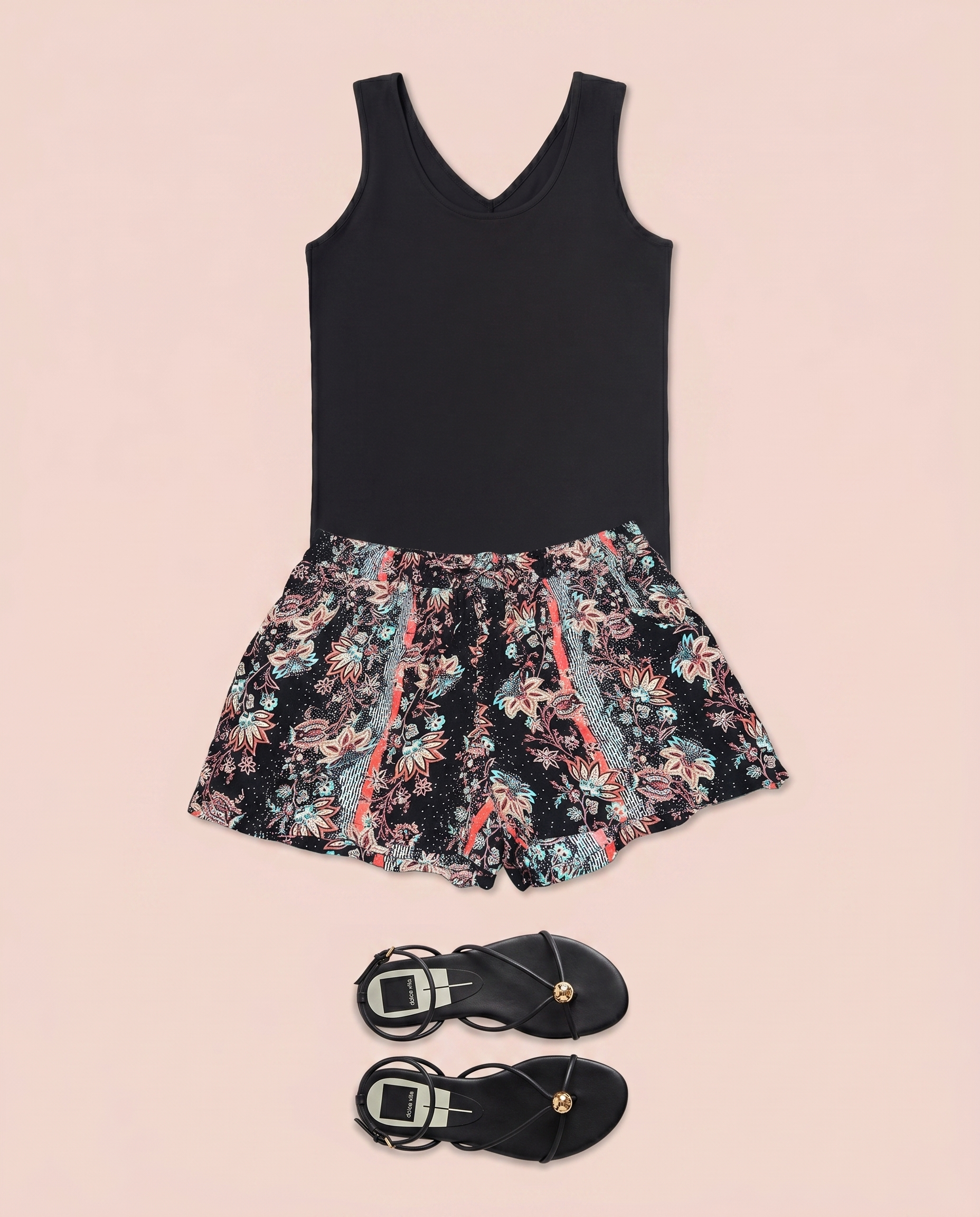 Black sleeveless top paired with floral print shorts on a beige background