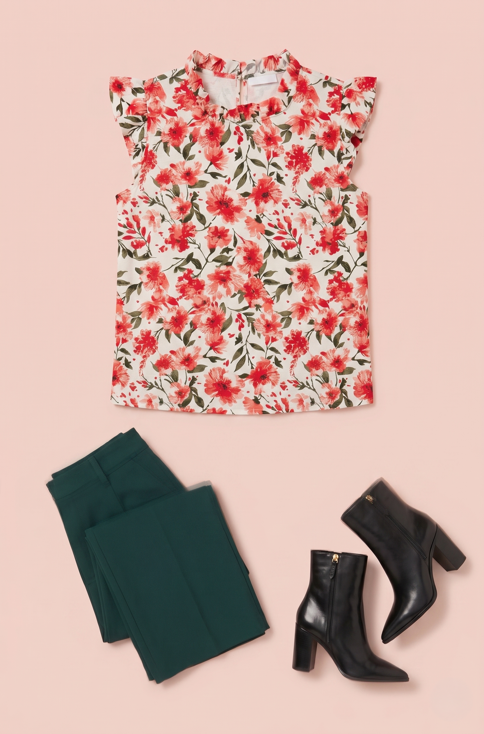 Red floral sleeveless blouse styled with dark green pants and black ankle boots on a beige background
