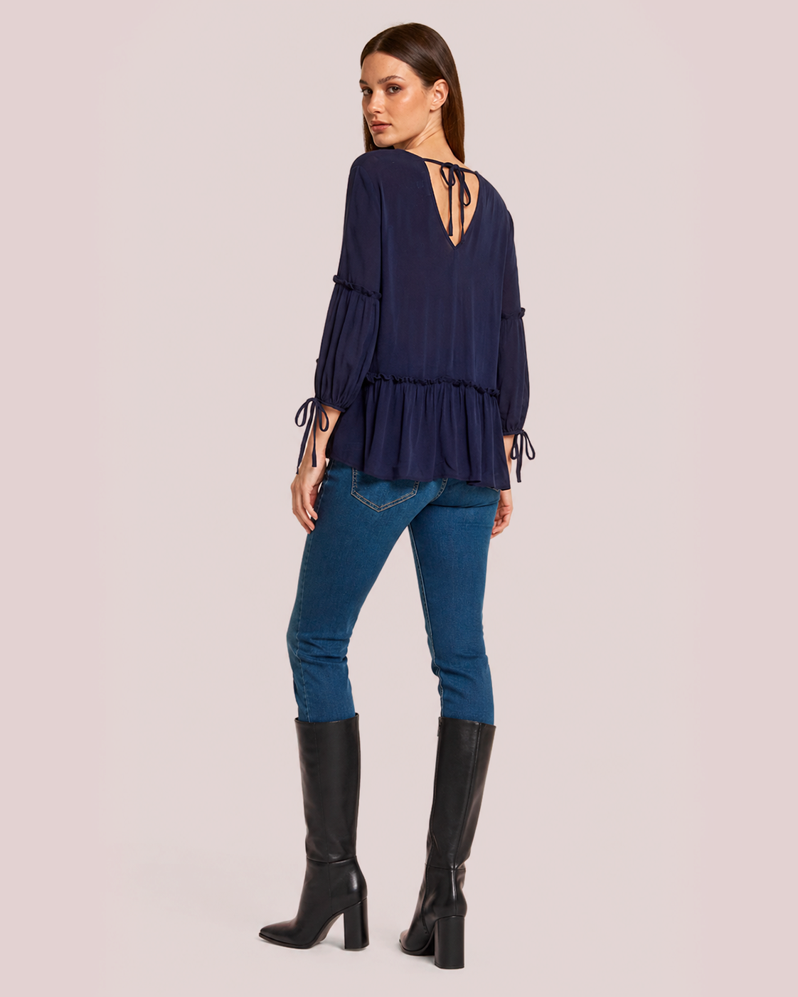 Soft Romance Peplum Blouse in Navy with back view with denim and black boots