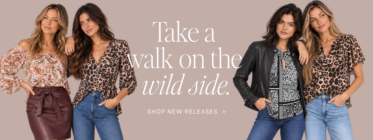 Four women modeling leopard-print and floral tops with jeans and a leather jacket against a solid taupe background, with the text 'Take a walk on the wild side. SHOP NEW RELEASES >>' in the center.