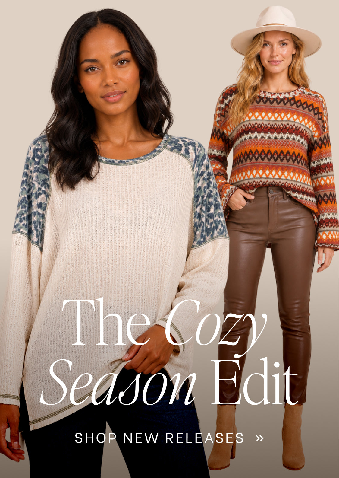 Two women modeling knit sweaters in a studio setting with the text 'The Cozy Season Edit' and 'SHOP NEW RELEASES >>'. The front model wears a cream ribbed sweater with blue-gray patterned sleeves, and the rear model wears a multicolor geometric knit sweater with brown faux-leather pants and a beige hat.