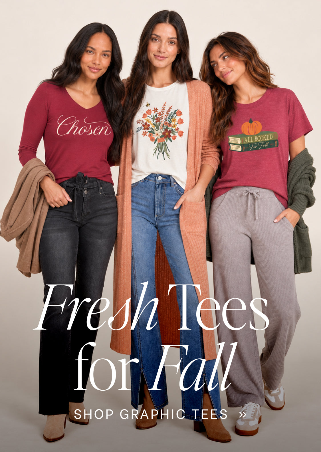 Three women modeling graphic tees in a studio setting with a warm beige background. The text overlay reads 'Fresh Tees for Fall' and 'SHOP GRAPHIC TEES'.