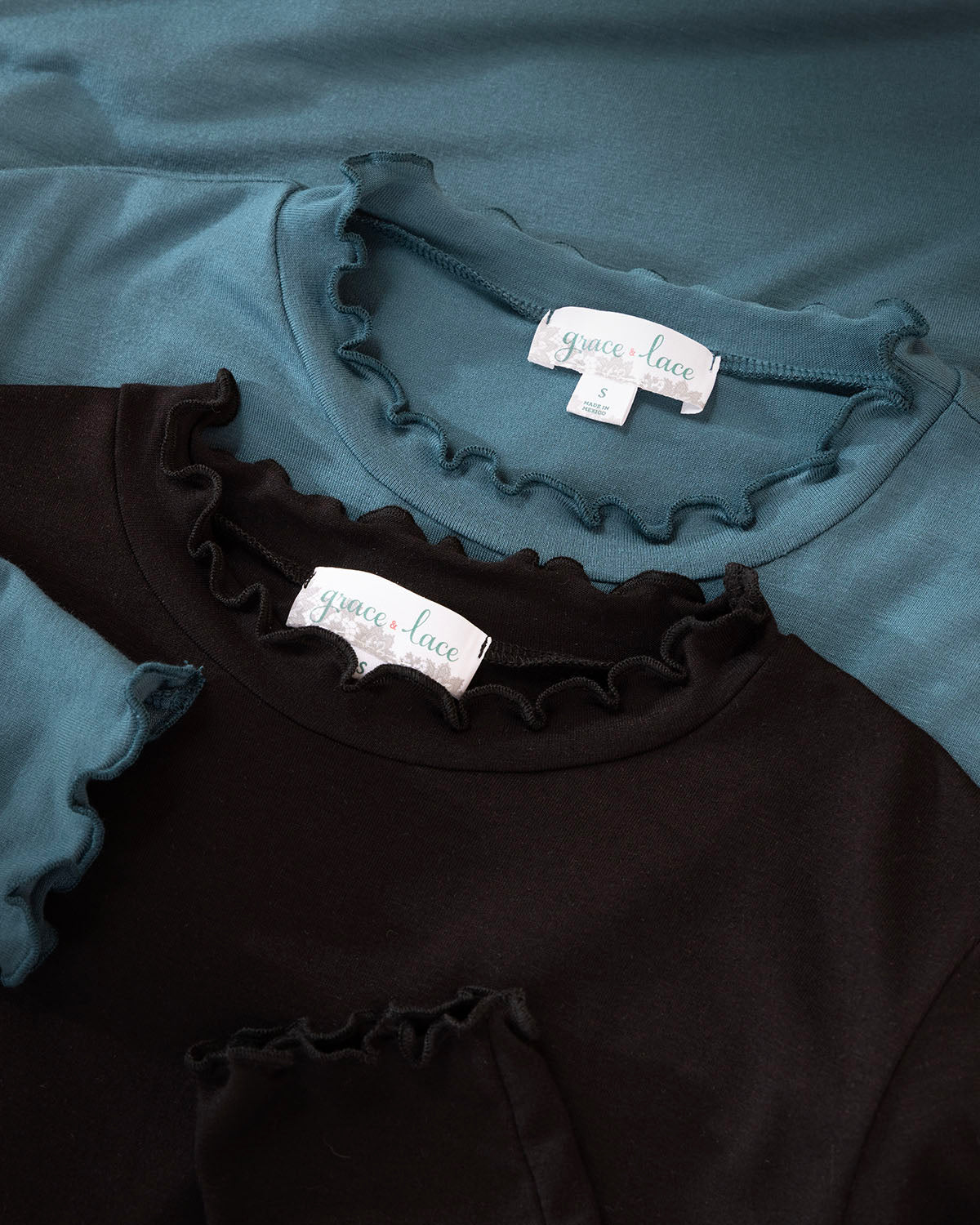 Black and teal shirts with ruffled details and visible Grace & Lace labels