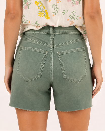 Back view of a woman wearing sage distressed shorts and a floral sleeveless blouse on a beige background