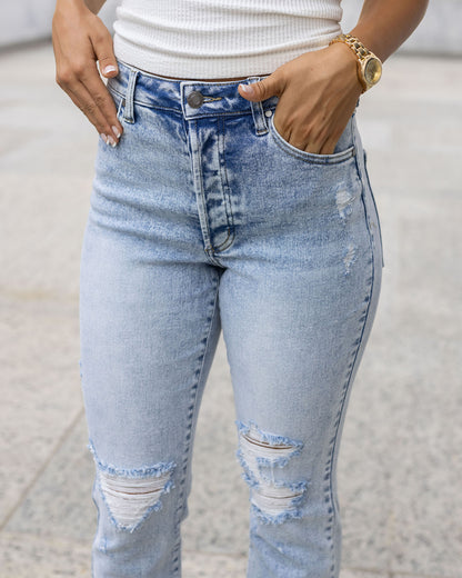 front close up view of premium high waisted mom jeans in distressed light mid-wash