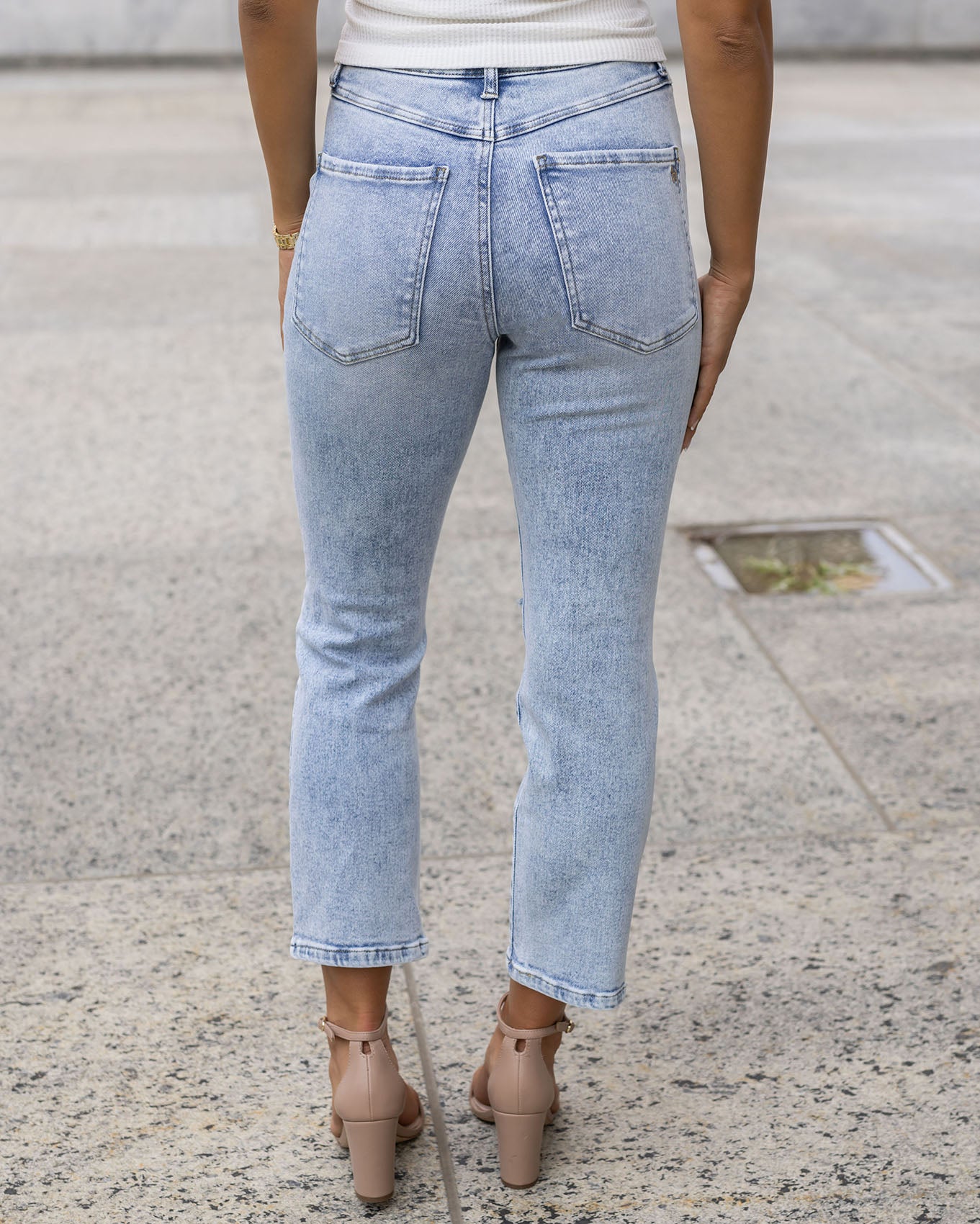 back view of premium high waisted mom jeans in distressed light mid-wash