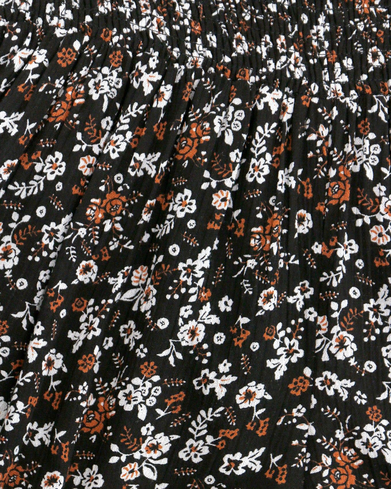Close up view of pattern on black ditsy smocked shorts