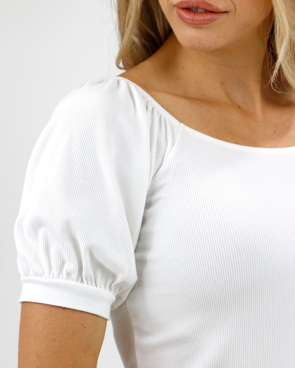 Close up view stock shot of sleeve on ivory ribbed knit top