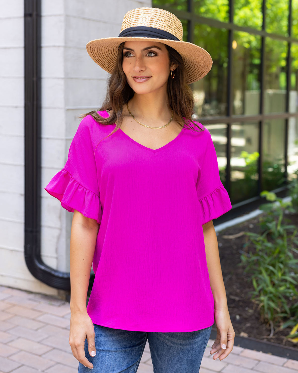 styled front view of hot pink ruffle sleeve shift top paired with sun hat and denim women's shift blouse