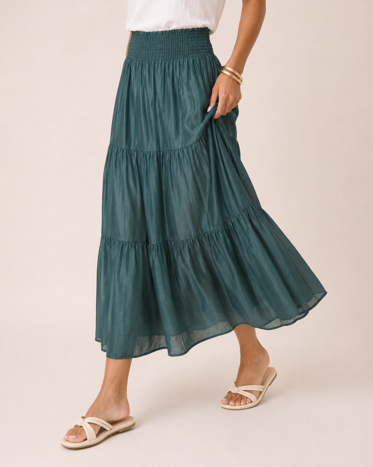 Side view close-up of a woman wearing an ivy tiered maxi skirt on a beige background