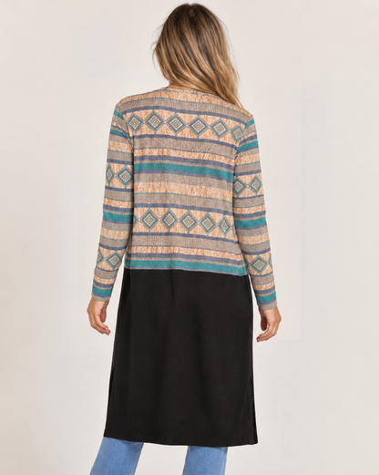 Back view of a woman wearing a long black maxi cardigan with multicolor geometric patterned detailing across the shoulders and upper back, featuring a relaxed, open-front silhouette on a beige background.