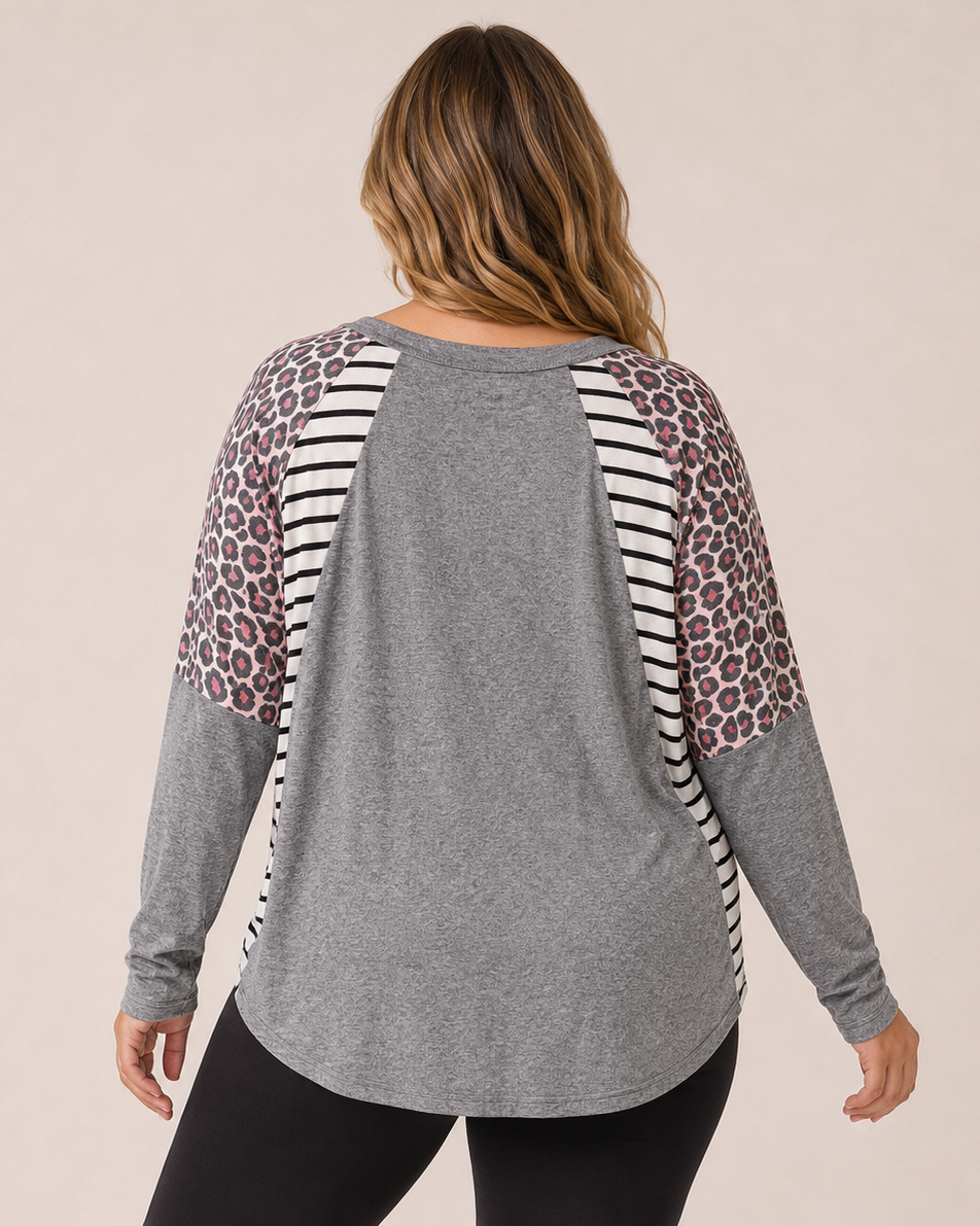 Back view of a woman wearing a gray oversized dolman sleeve tunic with black leggings on a beige background
