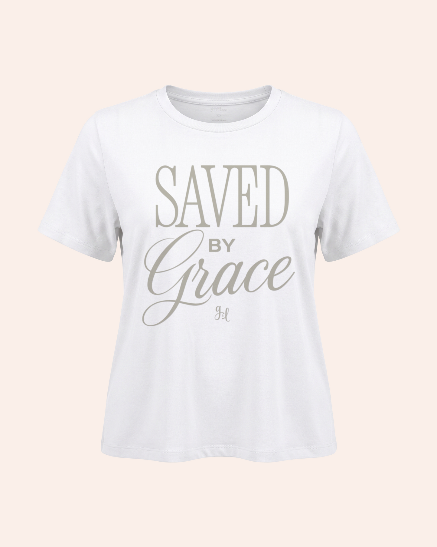 White t-shirt with 'Saved by Grace' text on a light pink background