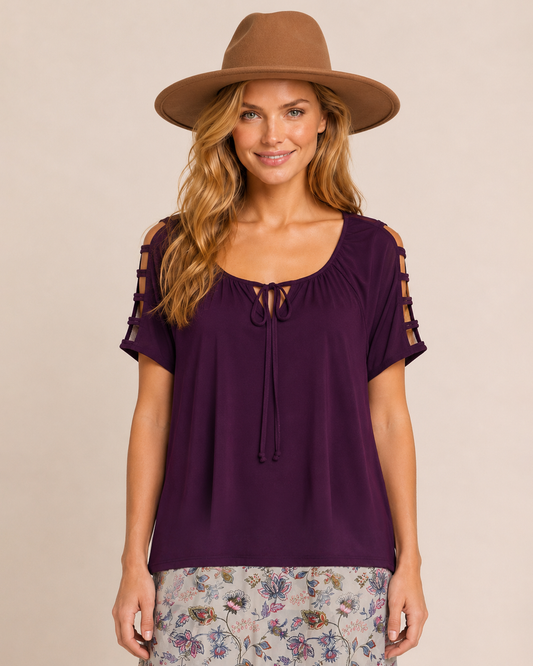 Woman wearing a purple ruffle-sleeve top with a gathered neckline on a beige background
