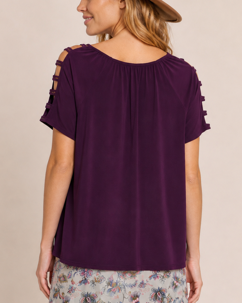 Back view of a woman wearing a purple ruffle-sleeve top with a floral midi skirt on a beige background