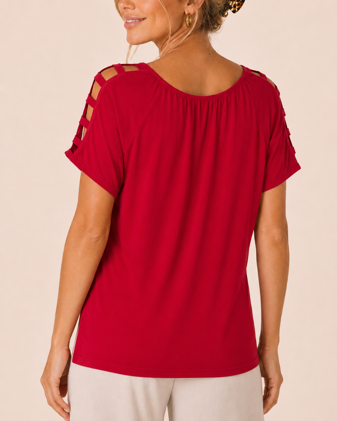 Back view of a woman wearing a red short-sleeve top with white wide-leg pants on a beige background