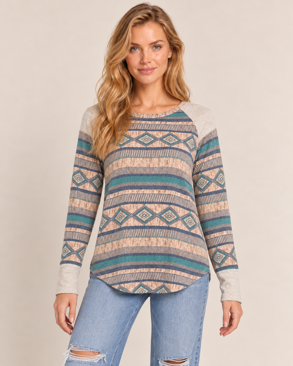 Cropped front view of a woman wearing a multicolor Southwestern geometric-pattern knit sweater with a wide neckline on a beige background.