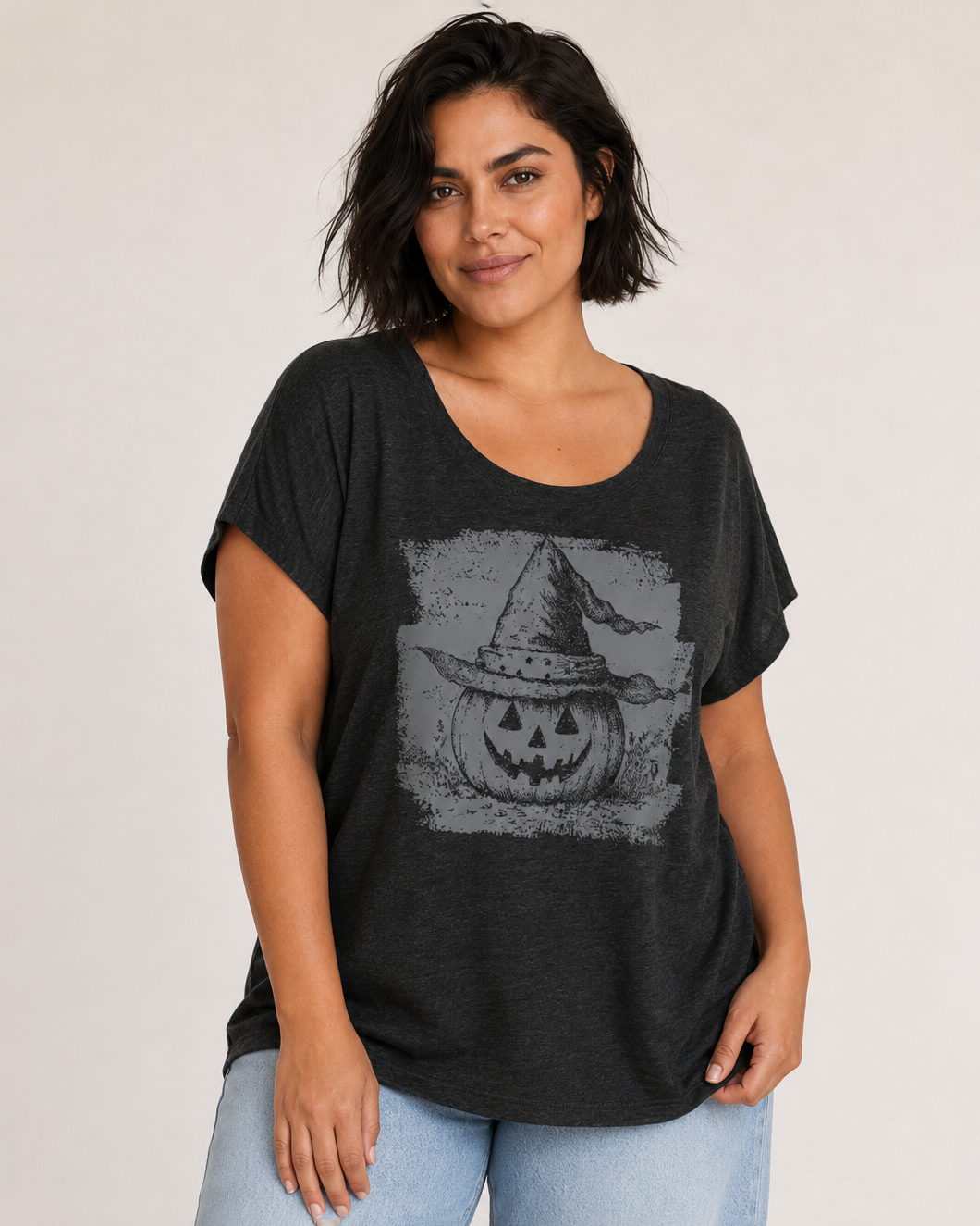 Front view of a woman wearing a black pumpkin graphic tee with a vintage-inspired graphic on a beige background
