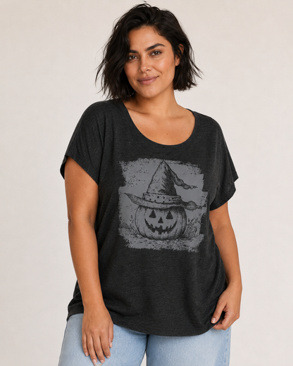 Front view of a woman wearing a black pumpkin graphic tee with a vintage-inspired graphic on a beige background