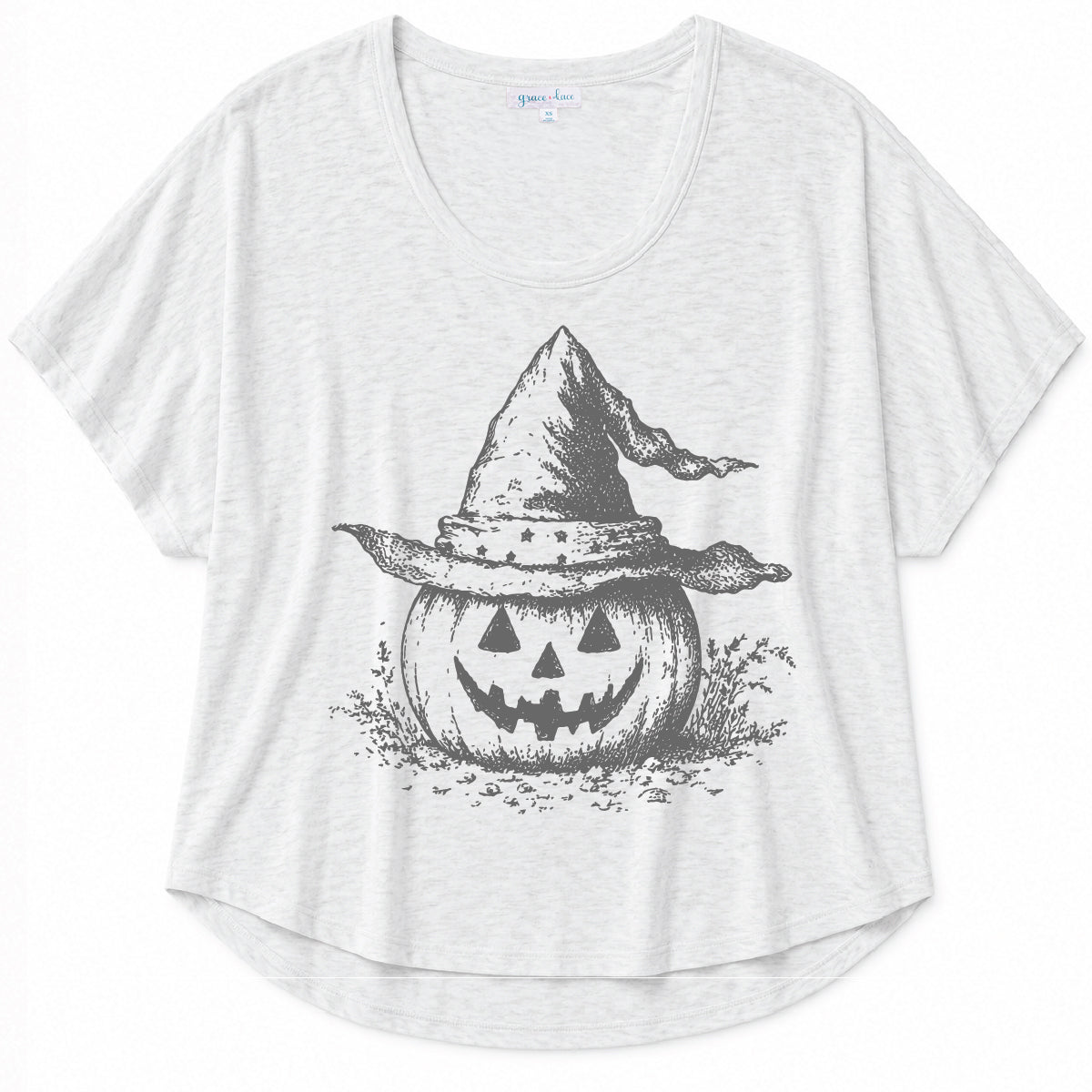 White graphic tee with a vintage-inspired pumpkin and witch hat design on a beige background
