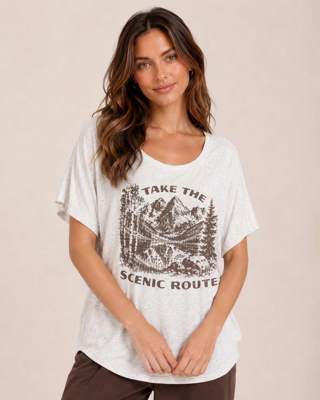 Front view of a woman wearing a navy graphic tee featuring a "Peace Comes in Waves" design and light wash denim shorts on a beige background